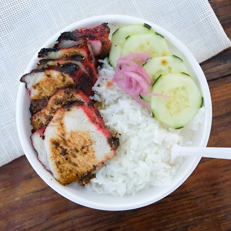Chubby Bao House's char siu pork with white rice, sliced cucumbers, and pickled red onions.